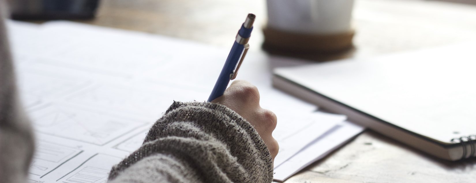 A closeup of someone drawing a plan