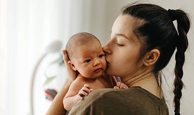 A mother kisses her baby