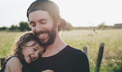 A smiling father and daughter