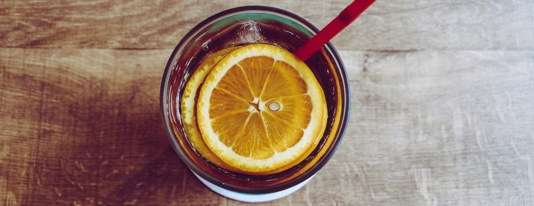 A drink with a lemon slice and a straw