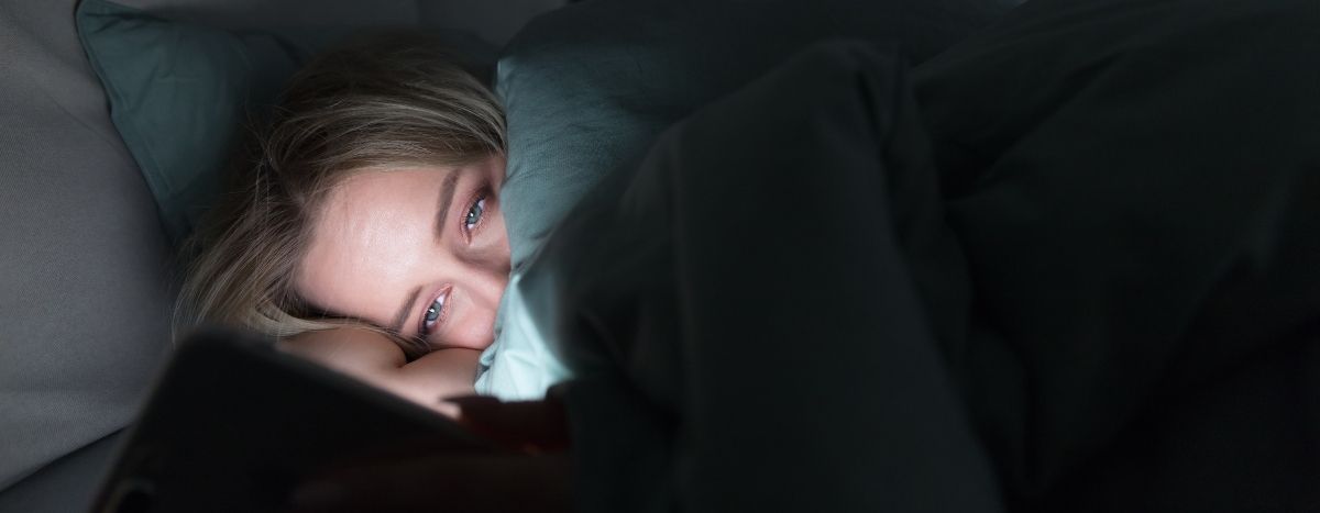 Person in bed looking at their phone