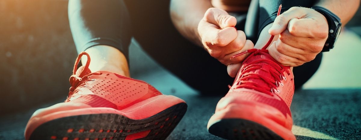 AIA Vitality | Person in activewear ties their laces | How to start (and enjoy) a new sport at any age