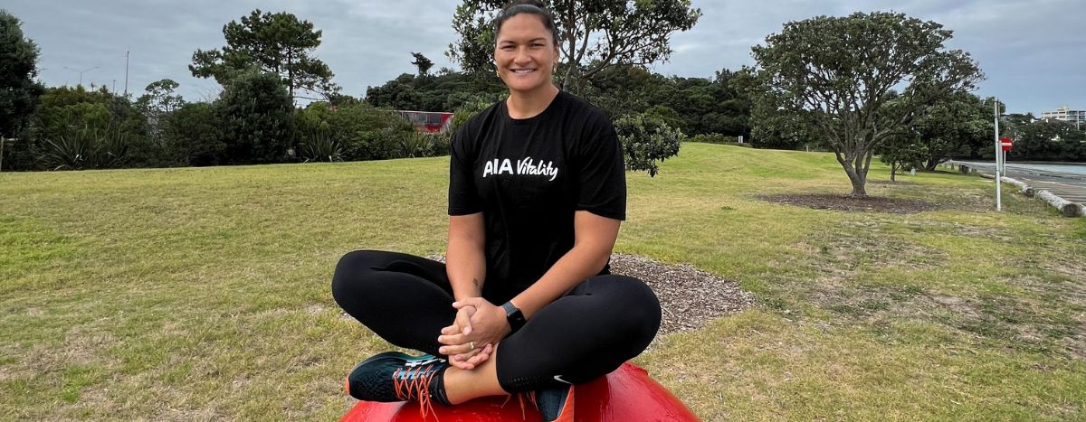 Image of Dame Valerie Adamas sitting on a boulder in a local park