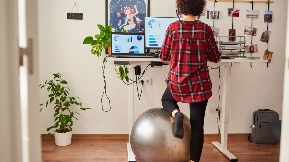 Person using a standing desk looking at computer screens