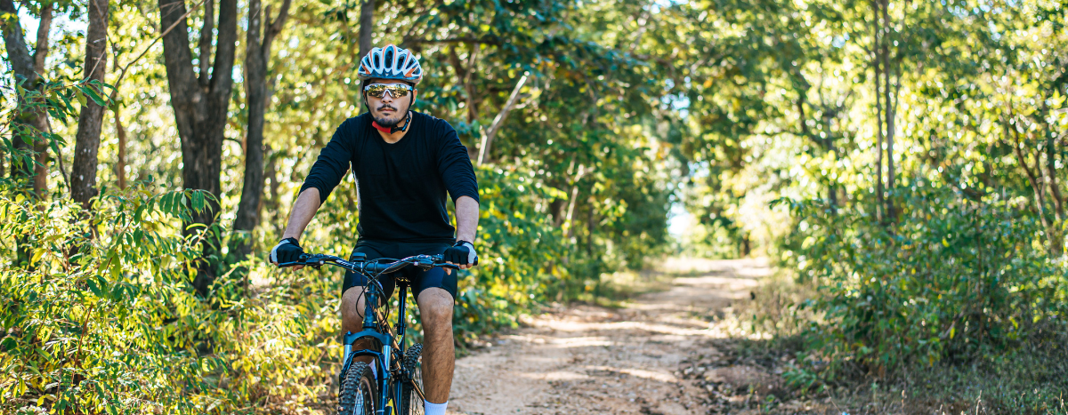 AIA Vitality | How to exercise safely during summer | Person riding a bike on a bush trail