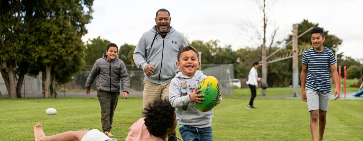 AIA Vitality | Move Well with the Heart Foundation | Family playing with rugby ball in the backyard