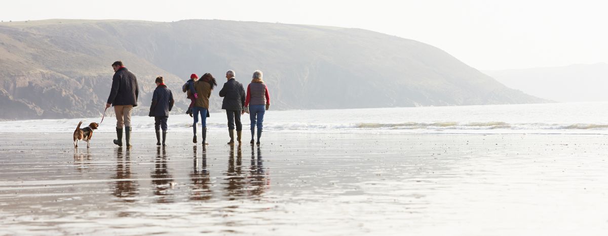 A family walking on the beach in winter clothess
