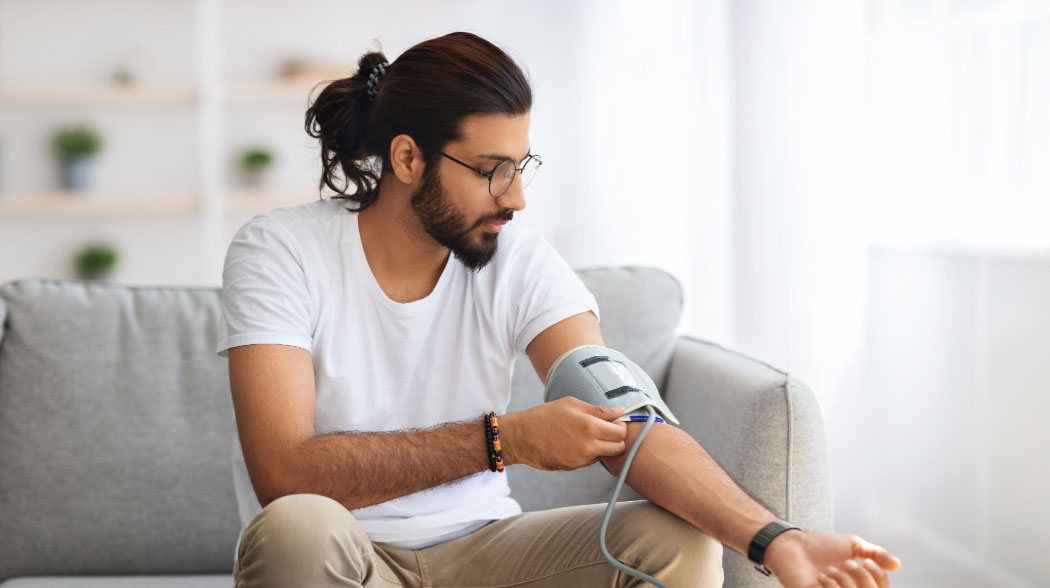 A person using a blood pressure monitor.