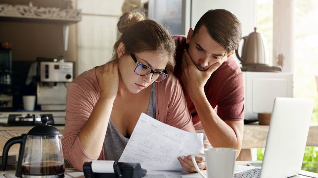 Two people sitting in the Kitchen looking at paperwork.