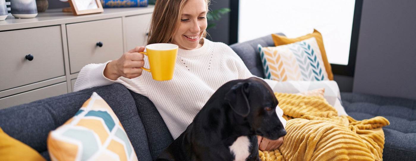 Woman relaxing on couch with dog