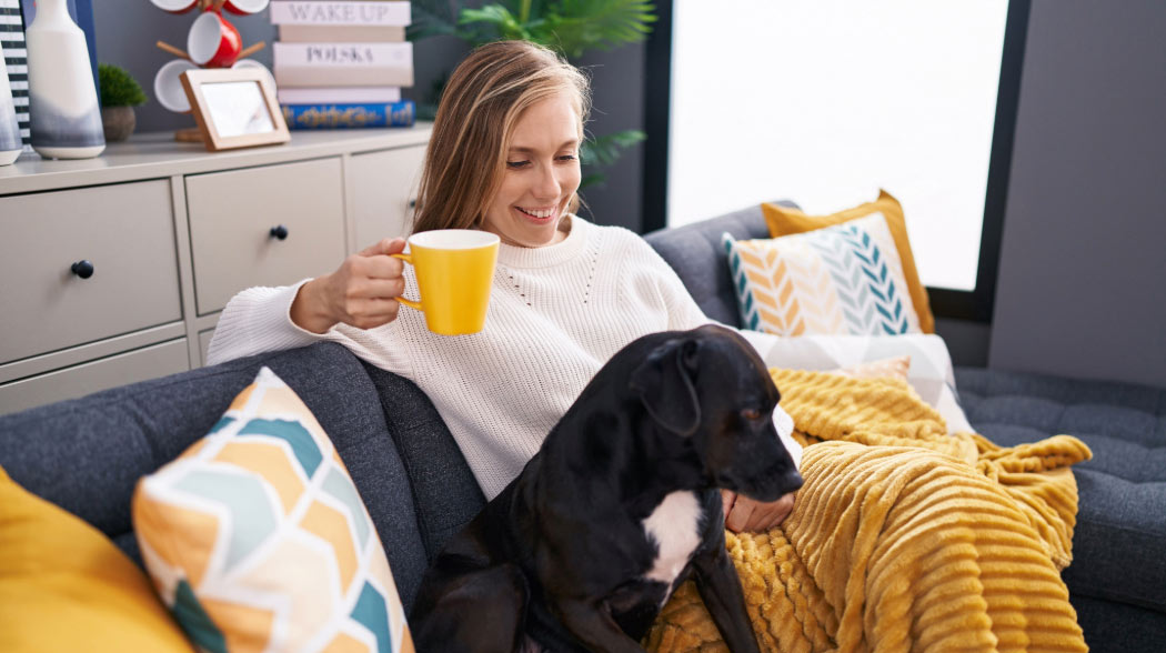 Woman relaxing on couch with dog