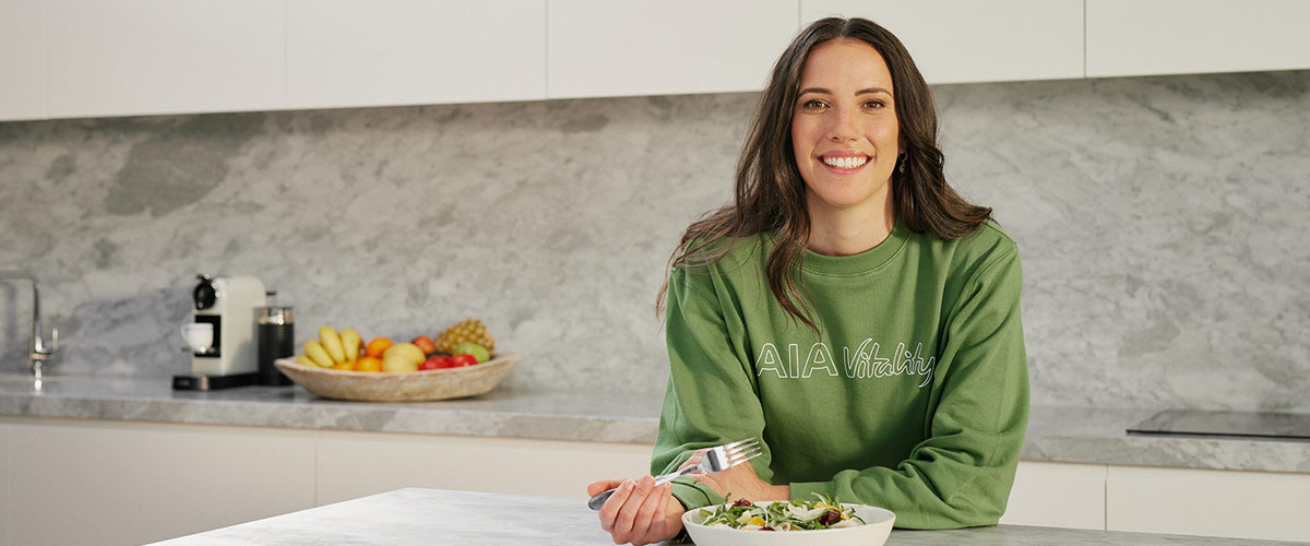 Marika Day in the kitchen with Green AIA Vitality Jumper